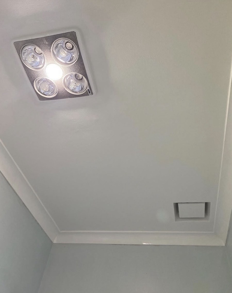 The same ceiling area after repainting, with a cleaner light ceiling surface around the light fitting and vent.